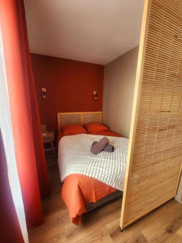 - une chambre avec un lit doté d'oreillers orange et d'un miroir dans l'établissement La Pause Plaisir - Studio à la Gare, à Caen
