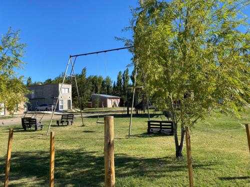 an empty park with swings and a tree at Casita el Emir in Plottier