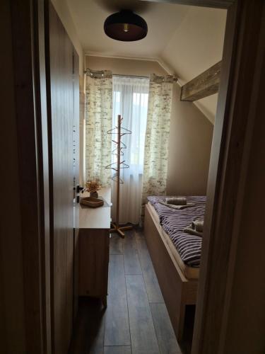 a small bedroom with a bed and a window at Vila LiMi in Oščadnica