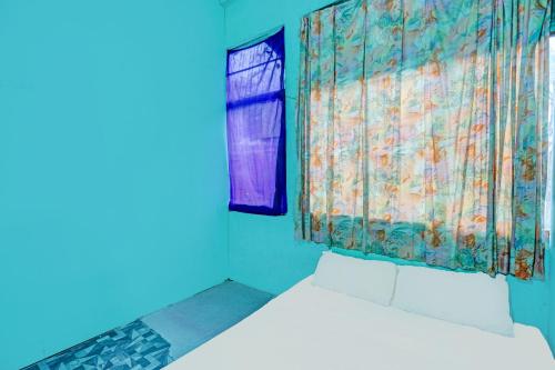 Cette chambre bleue comprend un lit et une fenêtre. dans l'établissement Hotel O Jodoh Stay SyariahNearPelabuhan Feri Harbor Bay, à Nagoya
