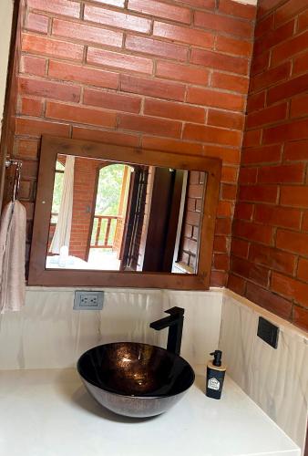 a sink in a bathroom with a mirror at The Lookout Hideaway in Baños