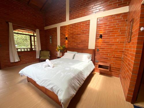 a bedroom with a large bed in a brick wall at The Lookout Hideaway in Baños