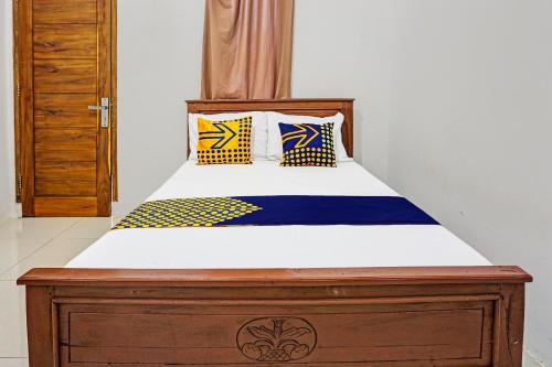a bed with yellow and blue pillows on it at OYO 92183 Komang Resort Klayar in Pacitan