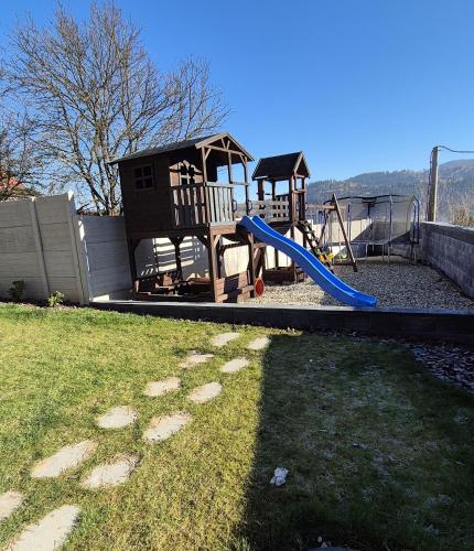 a playground with a blue slide in a yard at Vila LiMi in Oščadnica