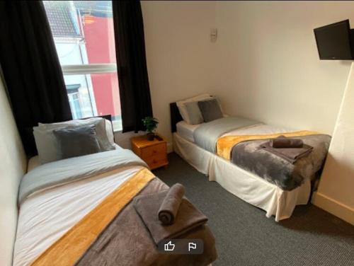 a room with two beds and a window at OYO Tudor Lodge - Redcar Beach in Redcar