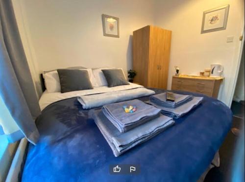 a bedroom with a blue bed with towels on it at OYO Tudor Lodge - Redcar Beach in Redcar