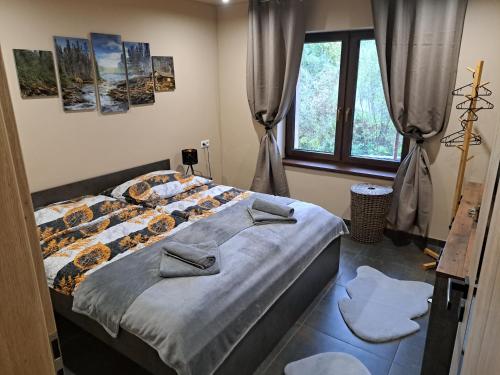 a bedroom with a bed and a window at Vila LiMi in Oščadnica