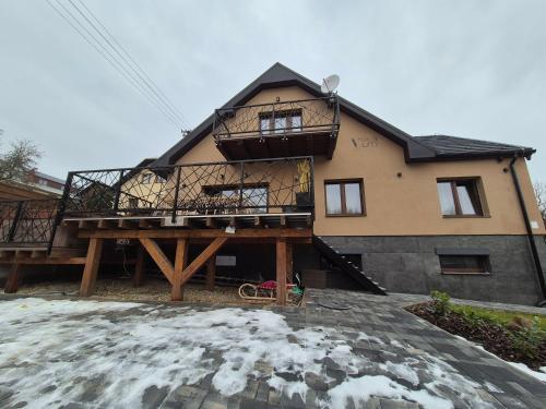 a house with a balcony and a deck at Vila LiMi in Oščadnica