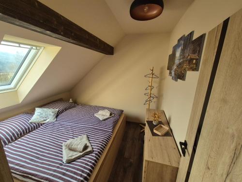 a bedroom with a bed and a window at Vila LiMi in Oščadnica