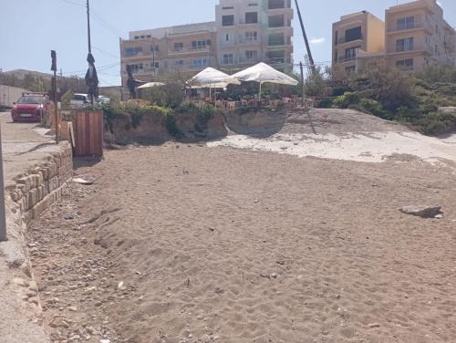 an empty beach with buildings in the background at Marsalforn's Cosy Room in Marsalforn