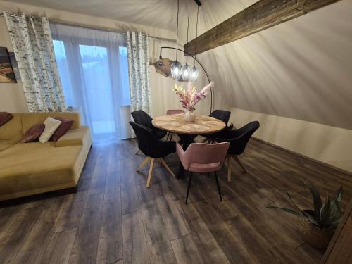 a living room with a table and chairs and a couch at Vila LiMi in Oščadnica