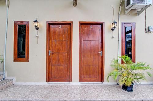 two wooden doors on the side of a building at OYO Life 92184 Mr Brown Homestay in Rembang