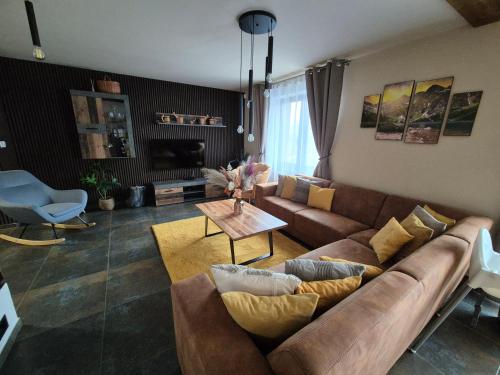 a living room with a couch and a table at Vila LiMi in Oščadnica