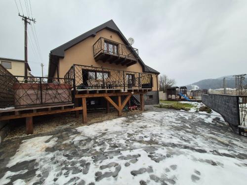 a house with snow on the ground in front of it at Vila LiMi in Oščadnica