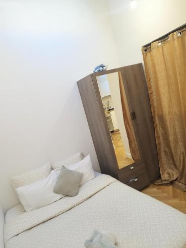 - une chambre avec un lit et un grand miroir dans l'établissement Spacieux appartement proche de Paris Stade de France Métro, à Aubervilliers