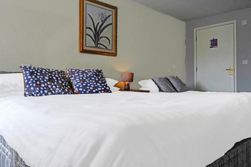 a bedroom with a large white bed with blue pillows at The Billingford Horseshoes in Scole
