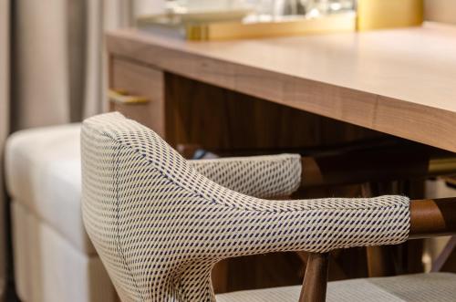 a chair sitting in front of a wooden desk at TURIM Av. Liberdade Hotel in Lisbon