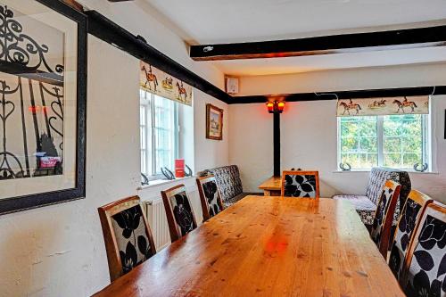 a dining room with a wooden table and chairs at The Billingford Horseshoes in Scole