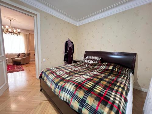 a bedroom with a bed and a jacket hanging on the wall at Cozy 5BD House With Frontyard in Tbilisi City