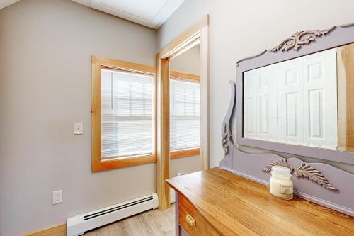 a living room with a tv on a wooden dresser at Lobster Cove Retreat in Prospect Harbor