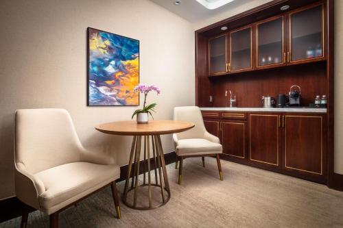 a room with a table and two chairs and a kitchen at Blossom Hotel Houston, Curio Collection by Hilton in Houston