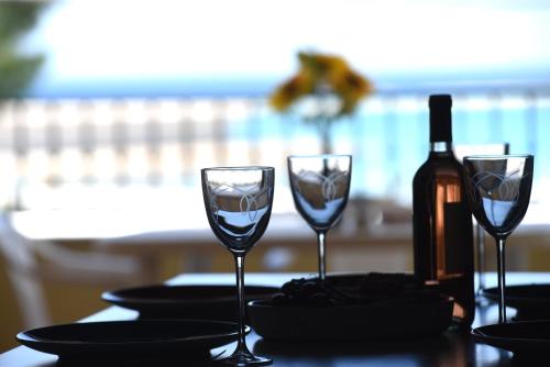 a table with two wine glasses and a bottle of wine at Lungomare Sant'Isidoro 1 in Sant'Isidoro