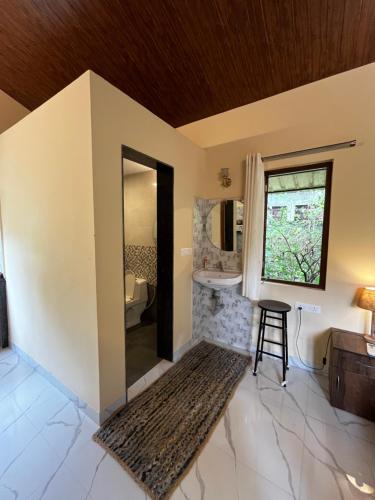a bathroom with a toilet and a sink and a stool at GOAROUND- Portuguese Villa at Anjuna Beach by Goaround Homes in Anjuna