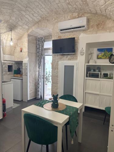 a kitchen and living room with a table and chairs at Semplice Dimora Ostuni in Ostuni