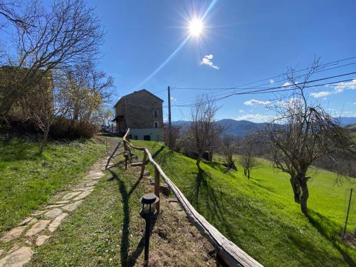 an old barn on a grassy hill with a fence at La Lupa e l'Orso in Berceto