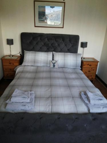 a bedroom with a large bed with towels on it at Celicall in Ballater