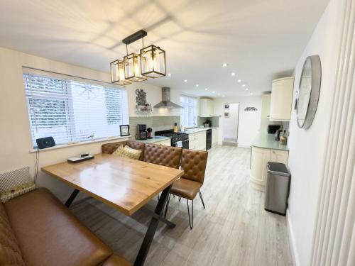 a kitchen and living room with a wooden table and couch at Seasons in Weymouth