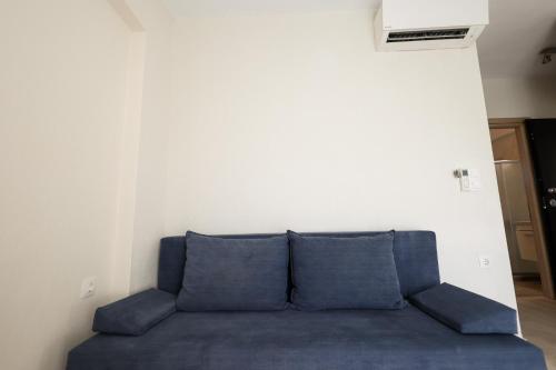 a blue couch in a room with a white wall at 4Keys Apartments Nikiti in Nikiti