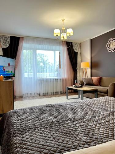 una camera da letto con un letto, un divano e una TV di Центр Медова Квартира подобово a Ternopilʼ
