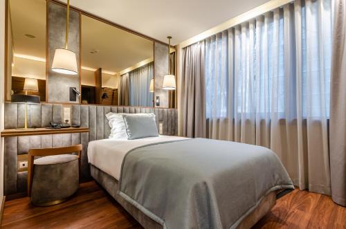 a bedroom with a bed and a large window at TURIM Av. Liberdade Hotel in Lisbon