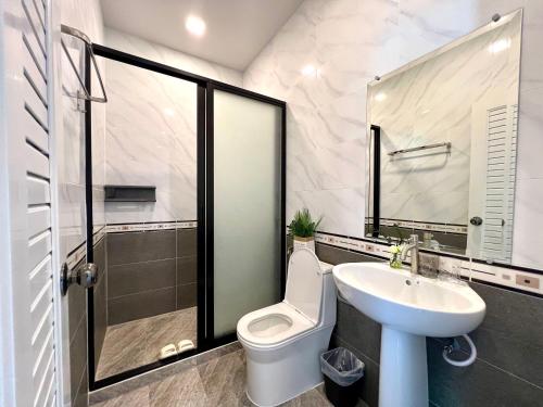 a bathroom with a white toilet and a sink at Chokchai village 9 in Nong Prue