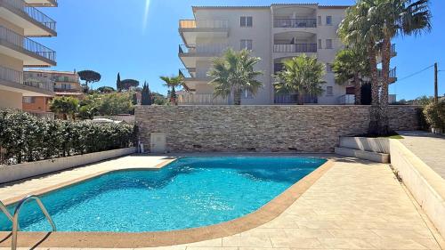 une piscine devant un immeuble dans l'établissement La Palmeraie, à Sainte-Maxime