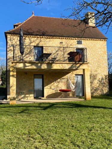 a house with a balcony and a yard at le chant des Verdiers in Saint-Aubin-de-Nabirat