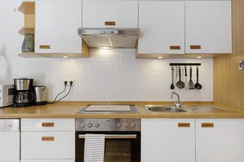 a kitchen with white cabinets and a sink at Hugenhof in Kirchzarten