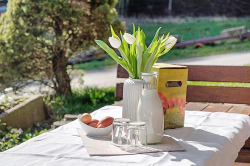 a table with a vase of flowers and a plate of eggs at Hugenhof in Kirchzarten
