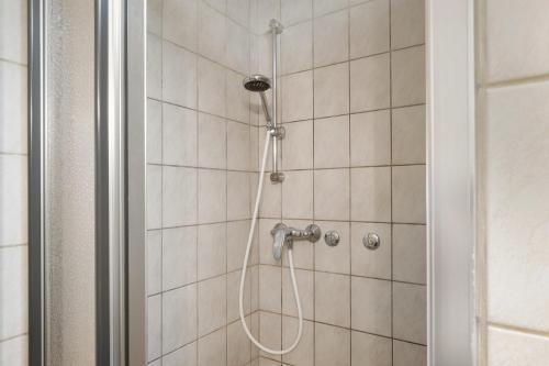 a shower with a shower head in a bathroom at Hugenhof in Kirchzarten