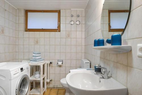 a bathroom with a washing machine and a sink at Hugenhof in Kirchzarten