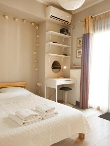 a bedroom with a bed and a desk and a window at Artistic elegant home in Afitos