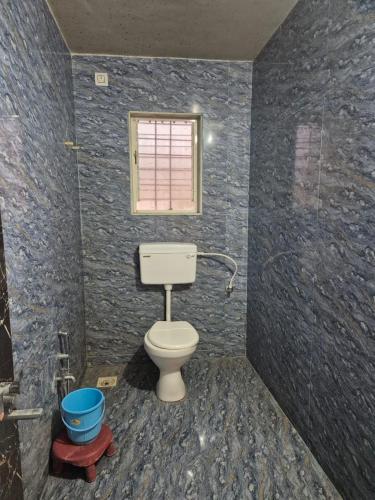 a bathroom with a toilet and a window at Tarasrushti lodge in Arvi