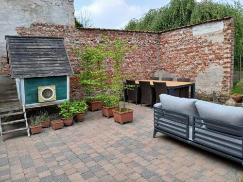 a patio with a couch and a dog house at Maison Miest in Watou