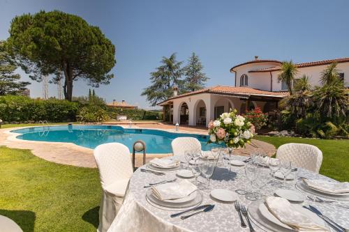 a table set up for a meal in front of a pool at Villa Habana in Fonte Nuova