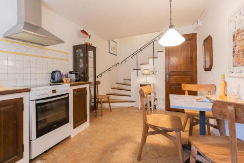 une cuisine et une salle à manger avec une table et des chaises dans l'établissement The Little House, à Bormes-les-Mimosas