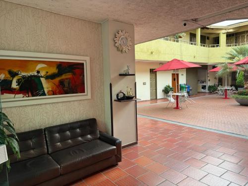 a lobby with a leather couch in a building at Hotel Primavera in Floridablanca