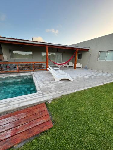 a backyard with a swimming pool and a house at Maura Del Mar casa de playa 4x4 in Mar Azul
