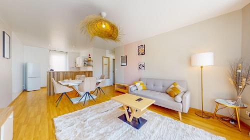 un salon avec un canapé et une table dans l'établissement L'Écrin Cozy - Nancy Thermal - cité judiciaire 4 personnes, à Nancy