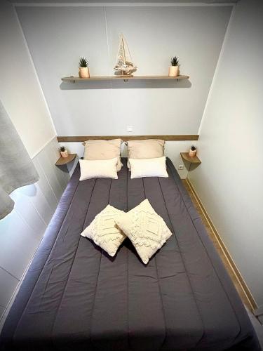 - un lit dans une chambre avec 2 oreillers dans l'établissement Tiny house Port la Nouvelle, à Port-la-Nouvelle